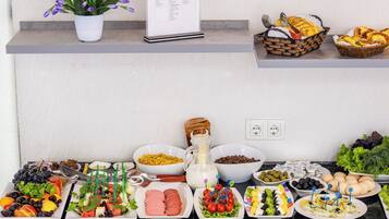 A buffet table with various food items and a menu sign.
