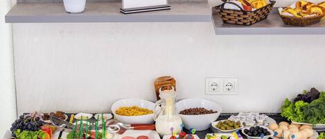 A buffet table with various food items and a menu sign.
