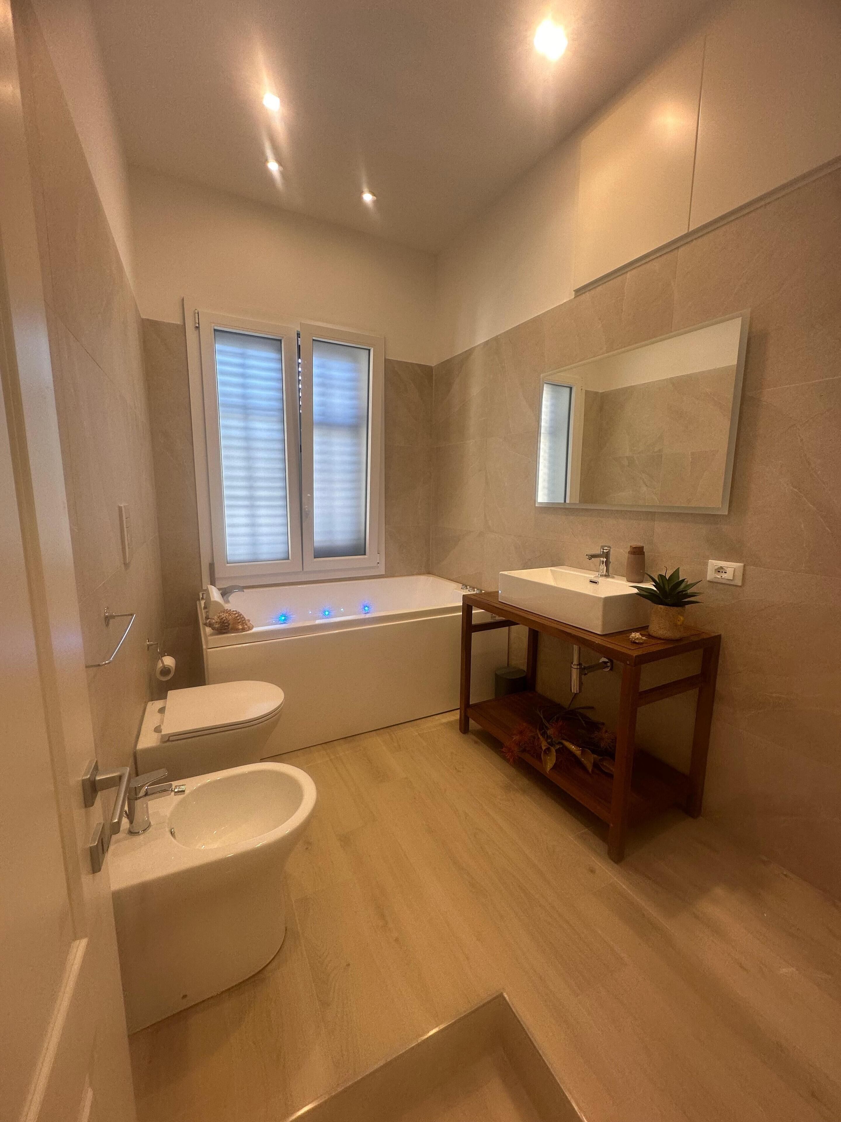 A modern bathroom with a bathtub, a sink, and a toilet.