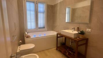 A modern bathroom with a bathtub, a sink, and a toilet.
