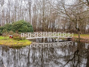A wooden bridge over a calm body of water with trees in the background. - 5 Star Holiday Home in Ansager (Ansager)