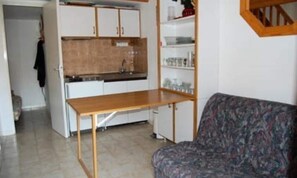 A compact living space with a kitchenette, a sofa, and a dining table. - Villa by Lake With Terrace in Occitanie (Leucate)