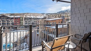 Ein Balkon mit Blick auf eine verschneite Stadt und Berge.