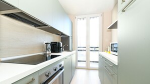 Uma cozinha moderna com fogão, forno e micro-ondas embutidos.