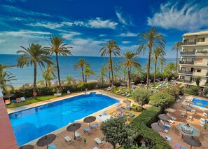 Un resort con piscina, lettini e palme.