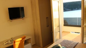 A bedroom with a bed, a desk with a chair, a television, and a wardrobe. - Comfortable Croatian Couple Retreat (Novalja)