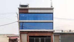 Un bâtiment moderne à deux étages, doté d’une grande façade en verre et d’une entrée de garage.