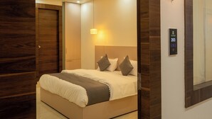 Une chambre moderne avec un grand lit, un ventilateur de plafond et un luminaire fixé au mur.