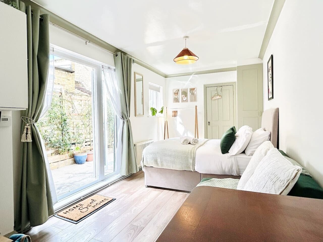 Une chambre à coucher avec un lit, une table de chevet, une fenêtre avec des rideaux et une porte.