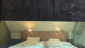 Ein Bett mit Kopfteil, Kissen und einem Nachttisch.