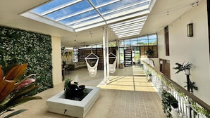 A spacious indoor area with a high ceiling, a glass roof, and a water feature. - Spacious 6 & 8 bedroom Chalet Vista al Mar with AC and solar power in Aguadilla (aguadilla)