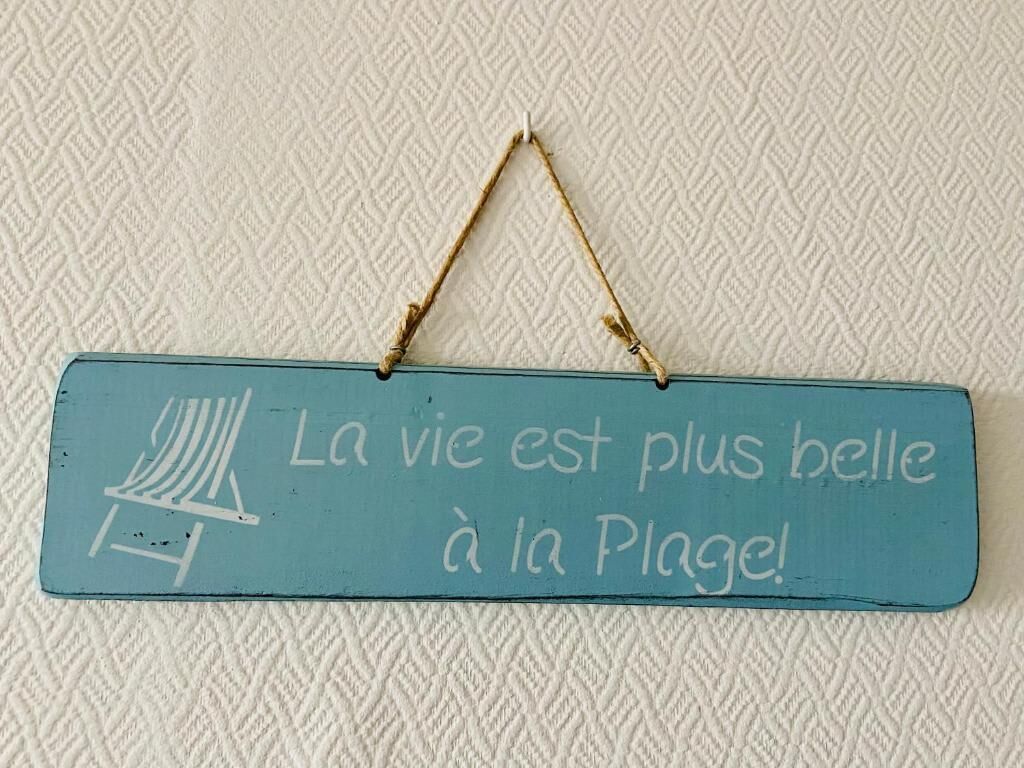 Une affiche représentant une chaise de plage et le texte : « La vie est plus belle à la plage ! »