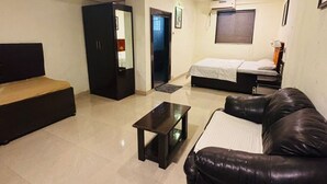 A hotel room with a bed, a sofa, a desk, and a wardrobe. - Hotel Silver Leaf (Panchgani)