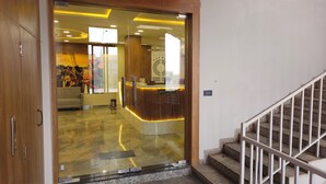 Un'area reception dal design moderno, con una scrivania reception e una scala che conduce a un piano superiore.