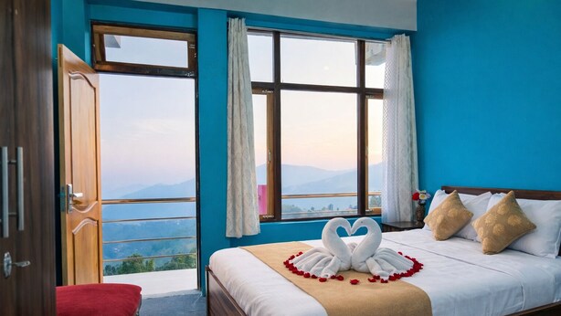 A bedroom with a bed, a bench, and a view of mountains through large windows. - Mukhia Homestay (Kurseong)