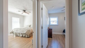 Een slaapkamer met een bed, een plafondventilator en een raam.