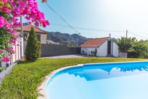 A residential property with a swimming pool, a small garden, and a view of the surrounding hills. - Villa Paixão by Atlantic Holiday (Machico)