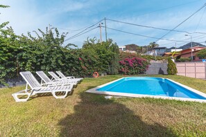 Un pati amb piscina, gandules i una tanca.