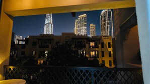Uma varanda com vista para edifícios altos à noite.