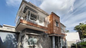 A two-story house with a balcony, a garage, and a tiled patio.