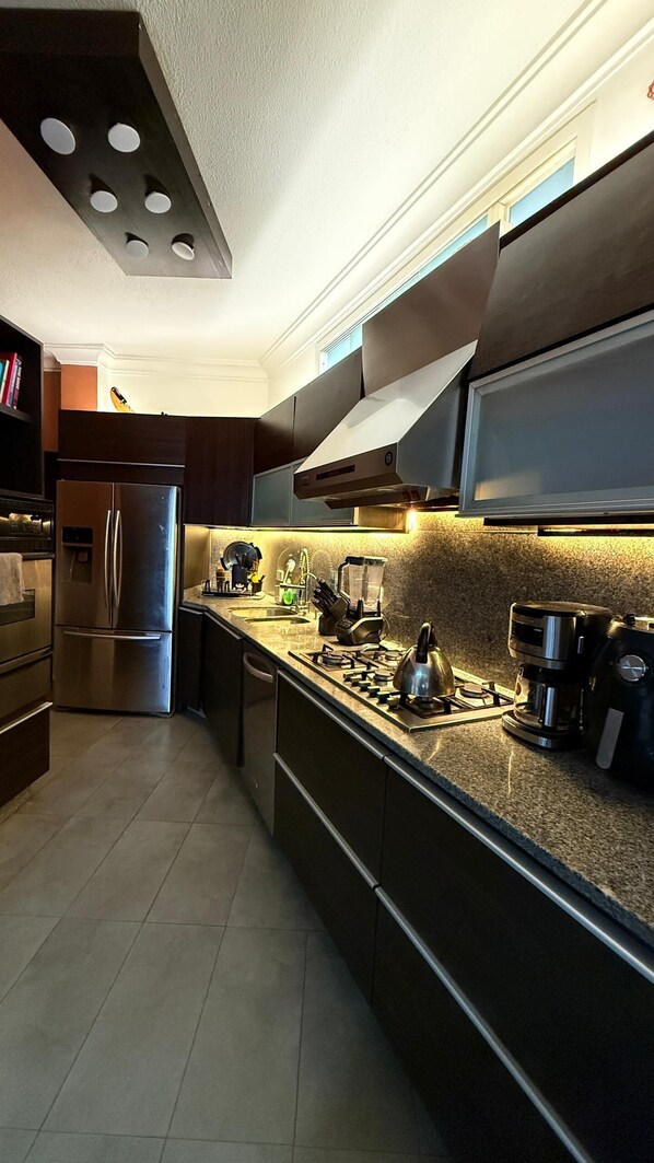 A modern kitchen with stainless steel appliances, a gas stove, and a built-in oven.