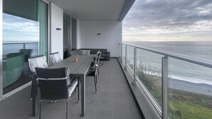 A balcony with a dining table and chairs, overlooking a body of water. - Pearl View by Atlantic Holiday (Funchal)