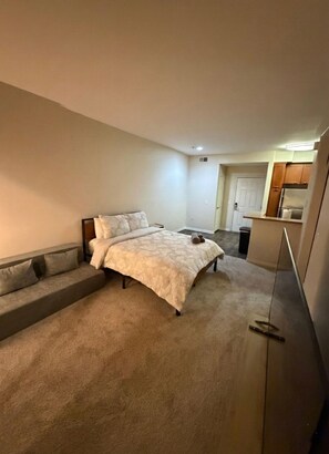 A bedroom with a bed, a sofa, and a kitchenette area. - Marina Del Rey Getaway - Close To Venice Beach (Marina del Rey)