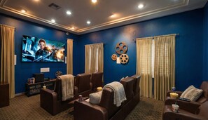 A home theater with a large flat-screen TV, leather recliner seating, and a popcorn bucket. - Fantastic Escape In Marina Del Rey - 1 Bedroom (Marina del Rey)