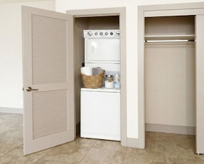 A compact laundry room with a washing machine and dryer, a wicker basket with towels, and a bottle of detergent. - Fantastic Escape In Marina Del Rey - 1 Bedroom (Marina del Rey)