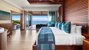 A modern bedroom with a large bed, wooden ceiling, and a view of the ocean. - SUMMER SALE! Discover paradise in a 3-bedroom oceanfront getaway - Alaeloa 28 (Lahaina)