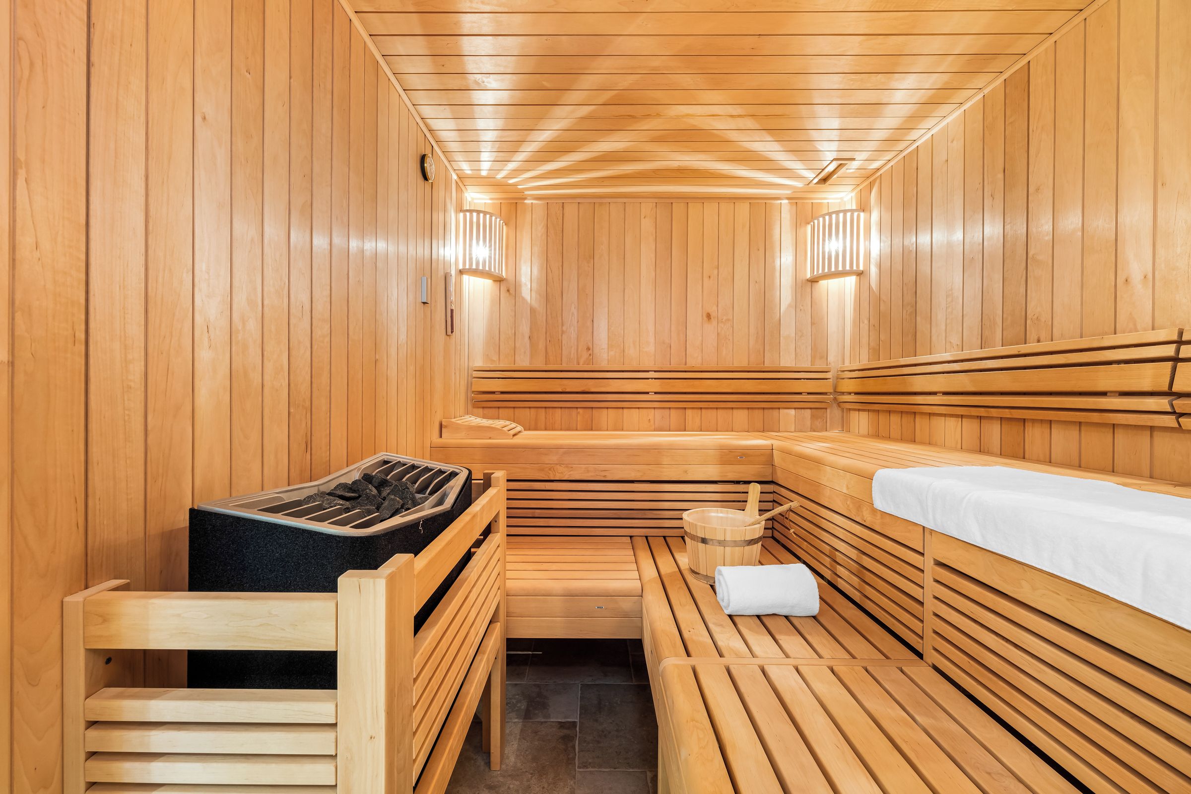 A sauna with wooden benches and a bench with a towel.