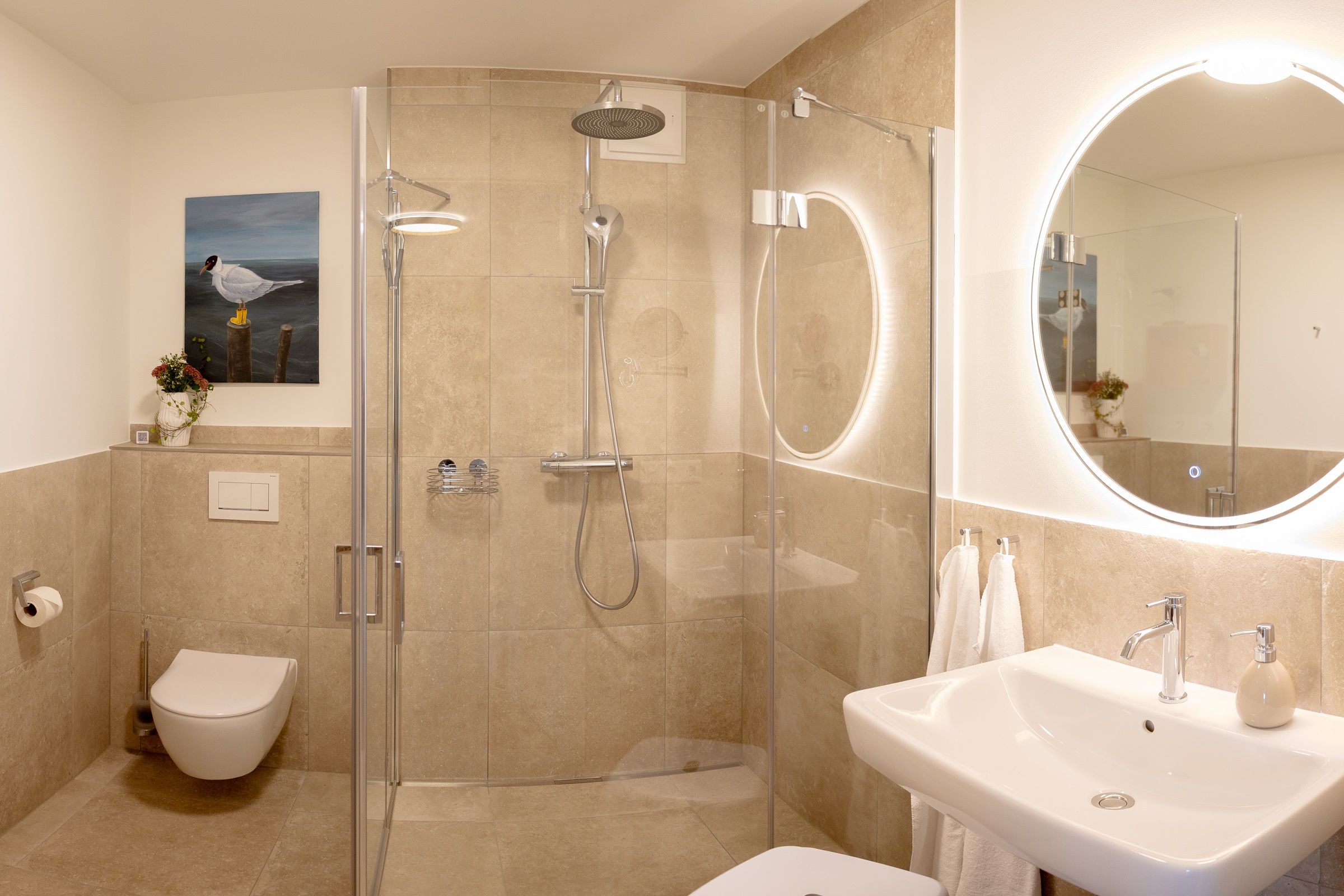 A modern bathroom with a glass-enclosed shower, a white sink, and a toilet.