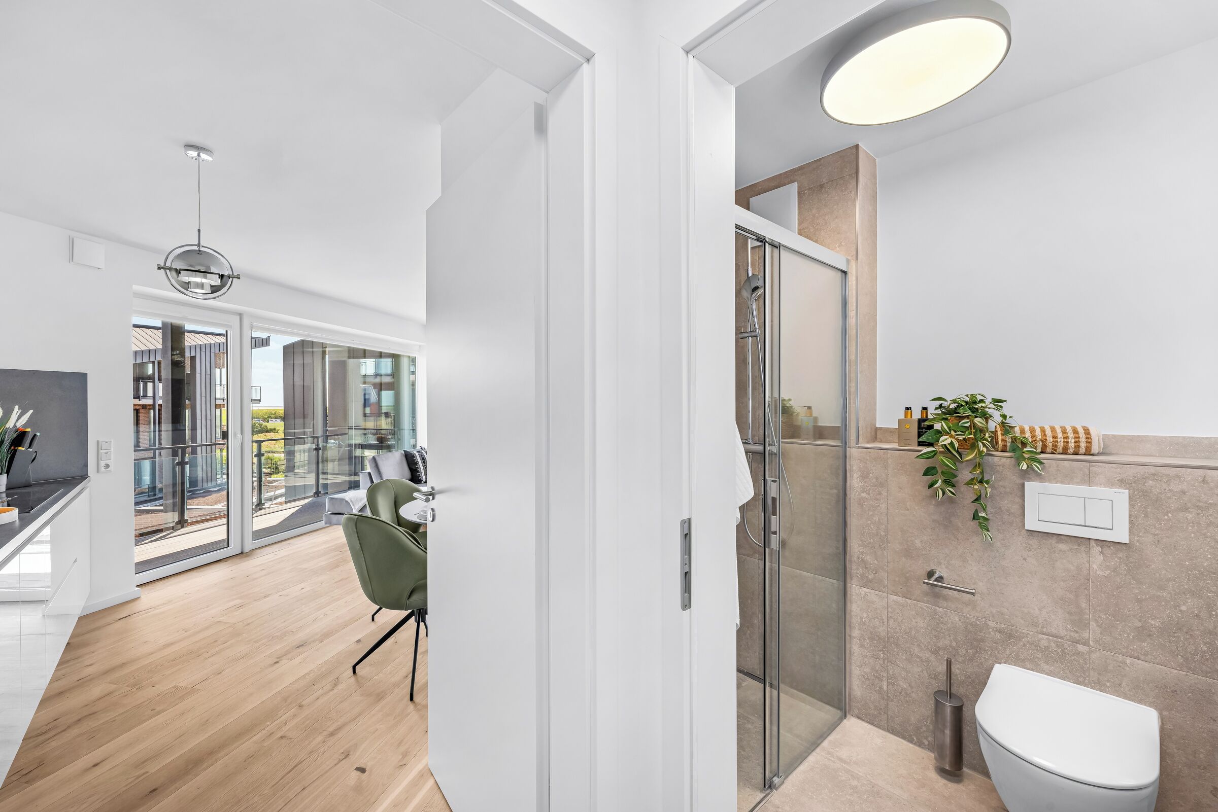 Een moderne badkamer met een douchecabine van glas, toilet en wastafel.