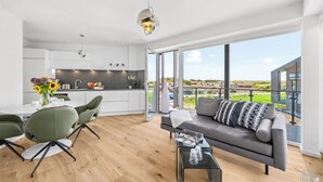 Un espace de vie moderne comprenant un coin repas, une cuisine et un balcon avec vue.