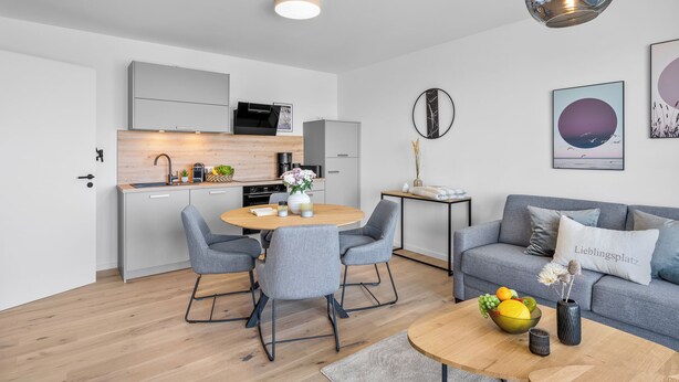 Eine moderne Wohnung mit Küche, Essbereich und Wohnzimmer.