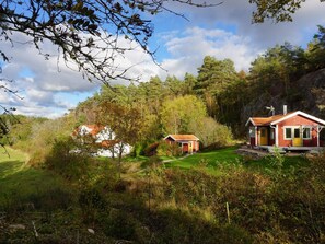 A rural setting with two small houses surrounded by dense forest and a clear sky. - 4 Star Holiday Home in Fjallbacka (Fjallbacka)