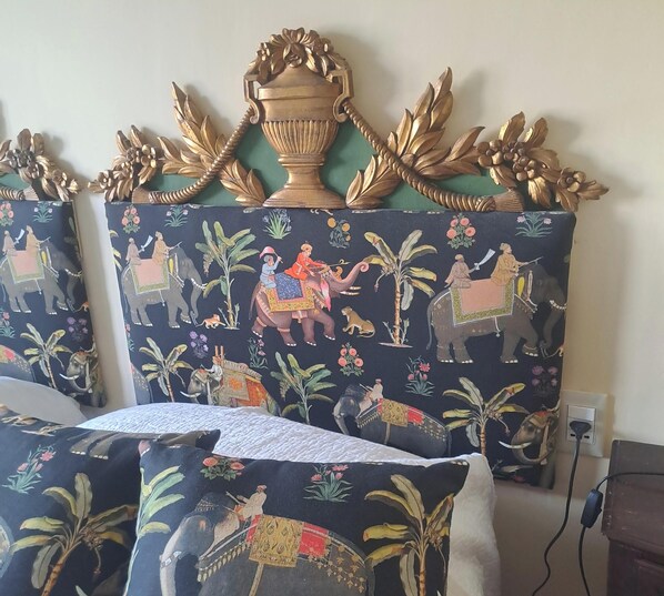 A room with a decorative headboard featuring a large urn and ornate leaves. The headboard has a dark fabric with elephant and floral patterns. - The Moon over the Harbor. Luxurious apartment on the waterfront in Santa Margherita Ligure (Santa Margherita Ligure)