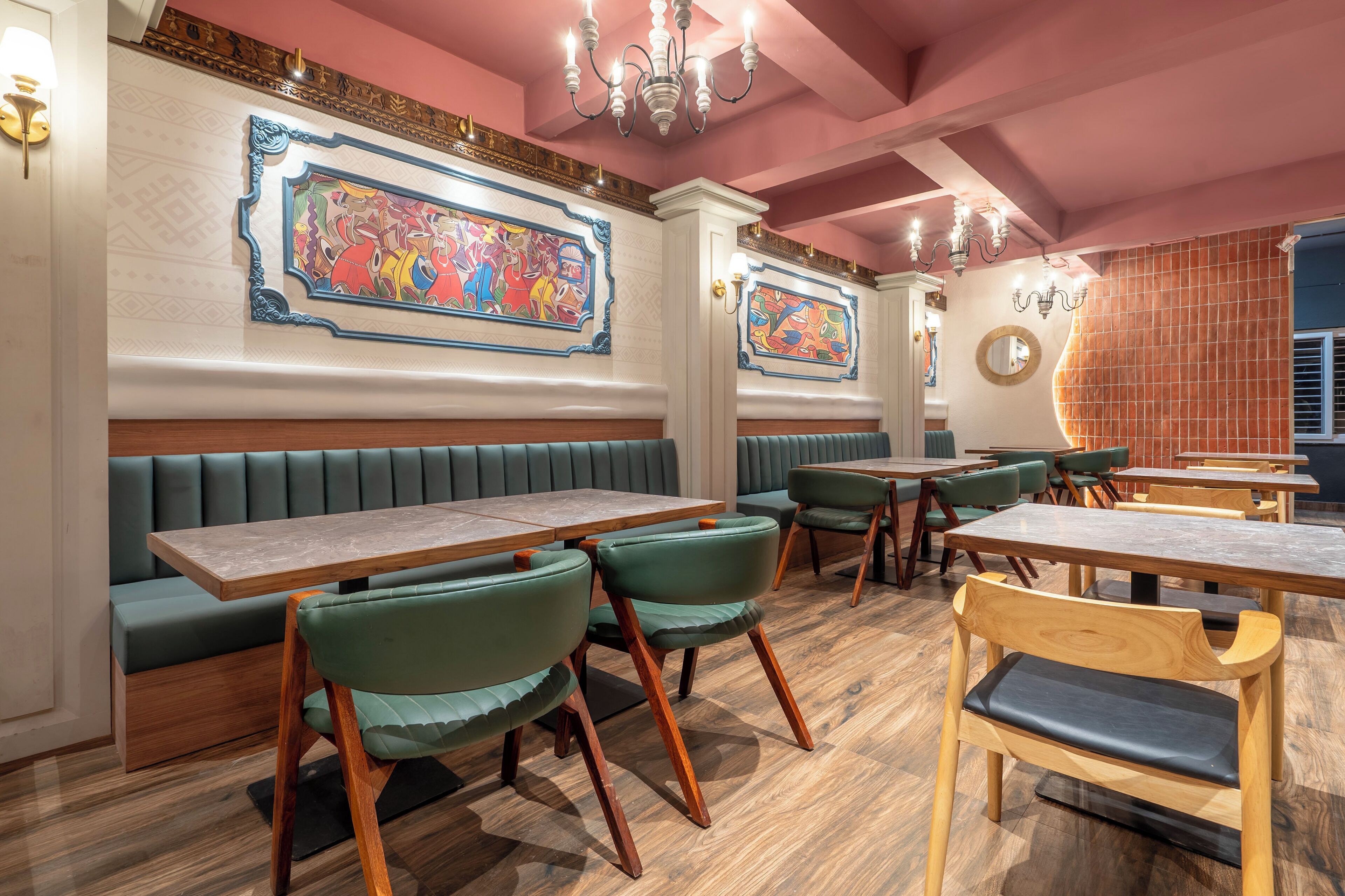 A restaurant interior with booths, tables, and green upholstered chairs.