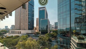 Un paisaje urbano con modernos rascacielos, cielo despejado y vistas del área metropolitana circundante.