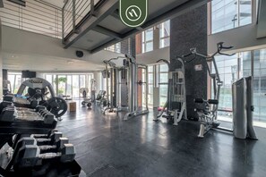 A modern gym with various exercise equipment, large windows, and a clean, spacious layout. - Bright 2BR in Polanco Steps From Antara Soumaya (Mexico City)