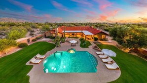 A large house with a swimming pool, surrounded by a well-maintained lawn and desert vegetation. - NEW 2M Luxe N Scottsdale Estate w Heated Pool (Scottsdale)