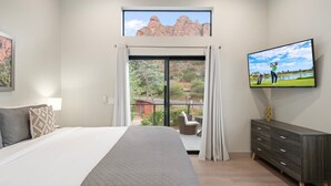 A bedroom with a large bed, a TV on the wall, a sliding glass door to a balcony, and a view of a golf course. - NEW Cimaron Butte View Terrace 2 Kings Firepit (Sedona)
