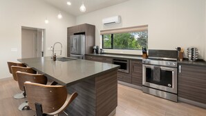 A modern kitchen with a central island, stainless steel appliances, and a view to the outdoors. - NEW Cimaron Butte View Terrace 2 Kings Firepit (Sedona)