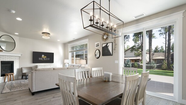 A spacious living room with a wooden dining table, white furniture, and a fireplace. - NEW Alamo Alpine Retreat Sleeps 11 3 Showers (Flagstaff)