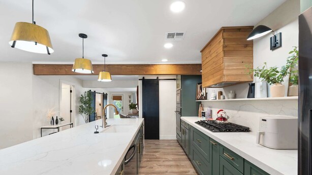 A modern kitchen with a marble countertop, green cabinets, and pendant lighting. - NEW The Palmera Updated 4BR Retreat w Pool (Scottsdale)