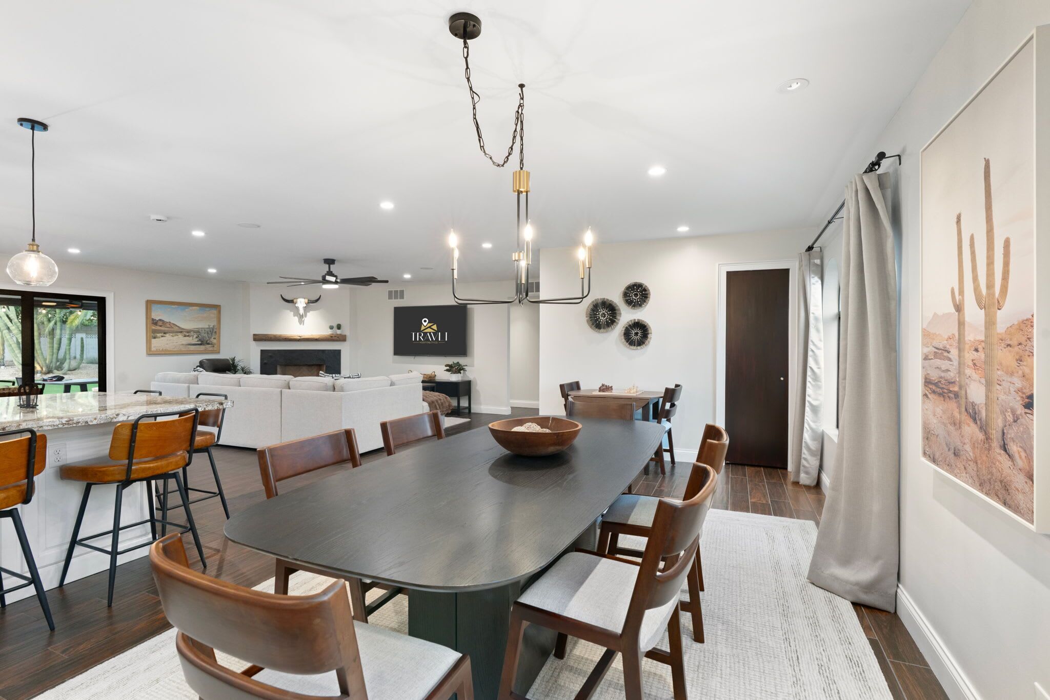 Un espace de salle à manger moderne, avec une grande table, des chaises et un lustre.