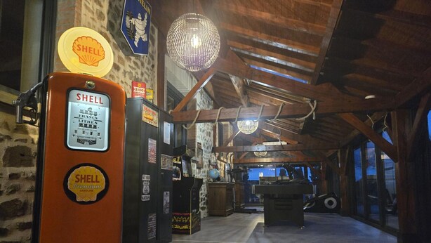 A vintage interior with a Shell gas pump, a neon sign, and a chandelier.
