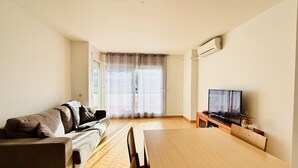 Ett vardagsrum med en soffa, en tv och ett matbord.