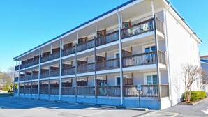 Un motel a più piani con balconi e un parcheggio.