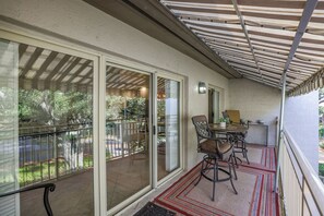 A covered outdoor patio with a table and chairs, a sliding glass door, and a metal railing. - 1690 Bluff Villas: 3 Bds, Next to South Beach Marina, Free Bikes (Hilton Head Island)